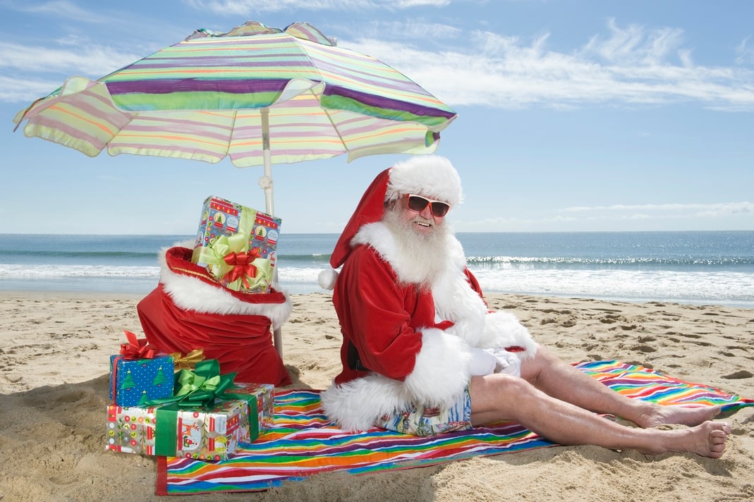 Santa-clause sitting on a beach smiling