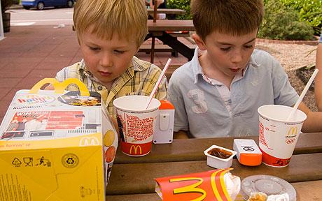 two kids eating mcdonald's happy meal