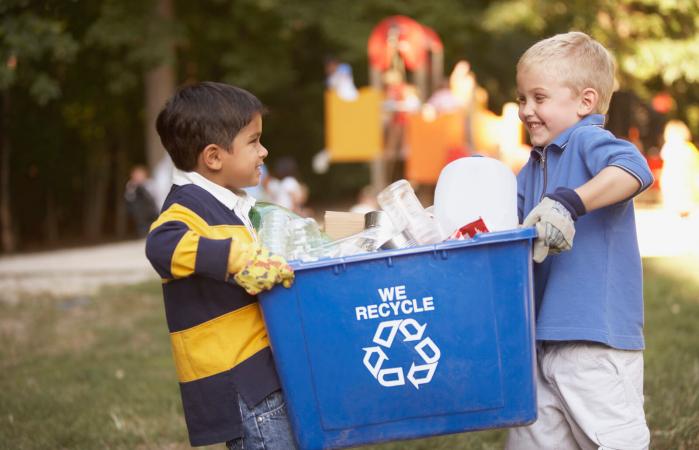 Kids carrying a recycling bin