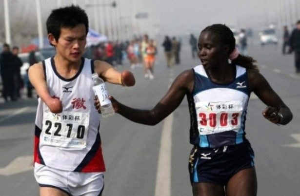 marathon runner helps runner with no arms