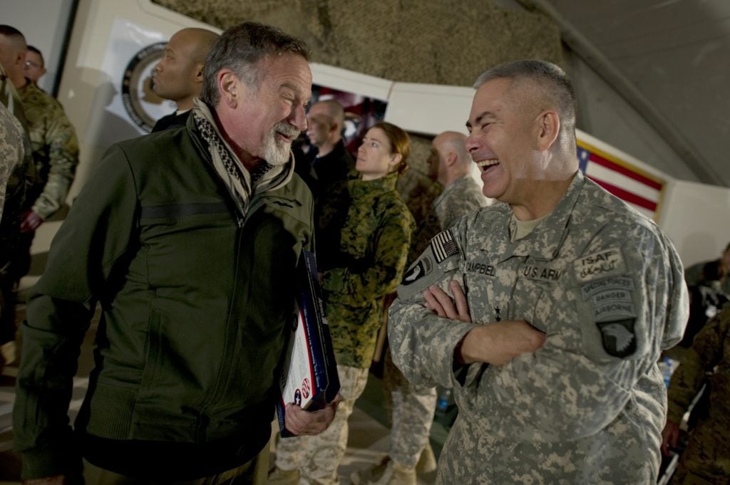 Comedian Robin Williams visits with Commanding General of Combined Task Force 101 U.S. Army Lt. Gen. John F. Campbell after the USO Holiday Tour show at Bagram Air Field, Afghanistan.