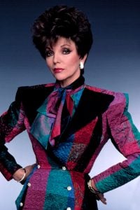 Tv-kuningatar Joan Collins sporting a professional outfit with shoulder pads present