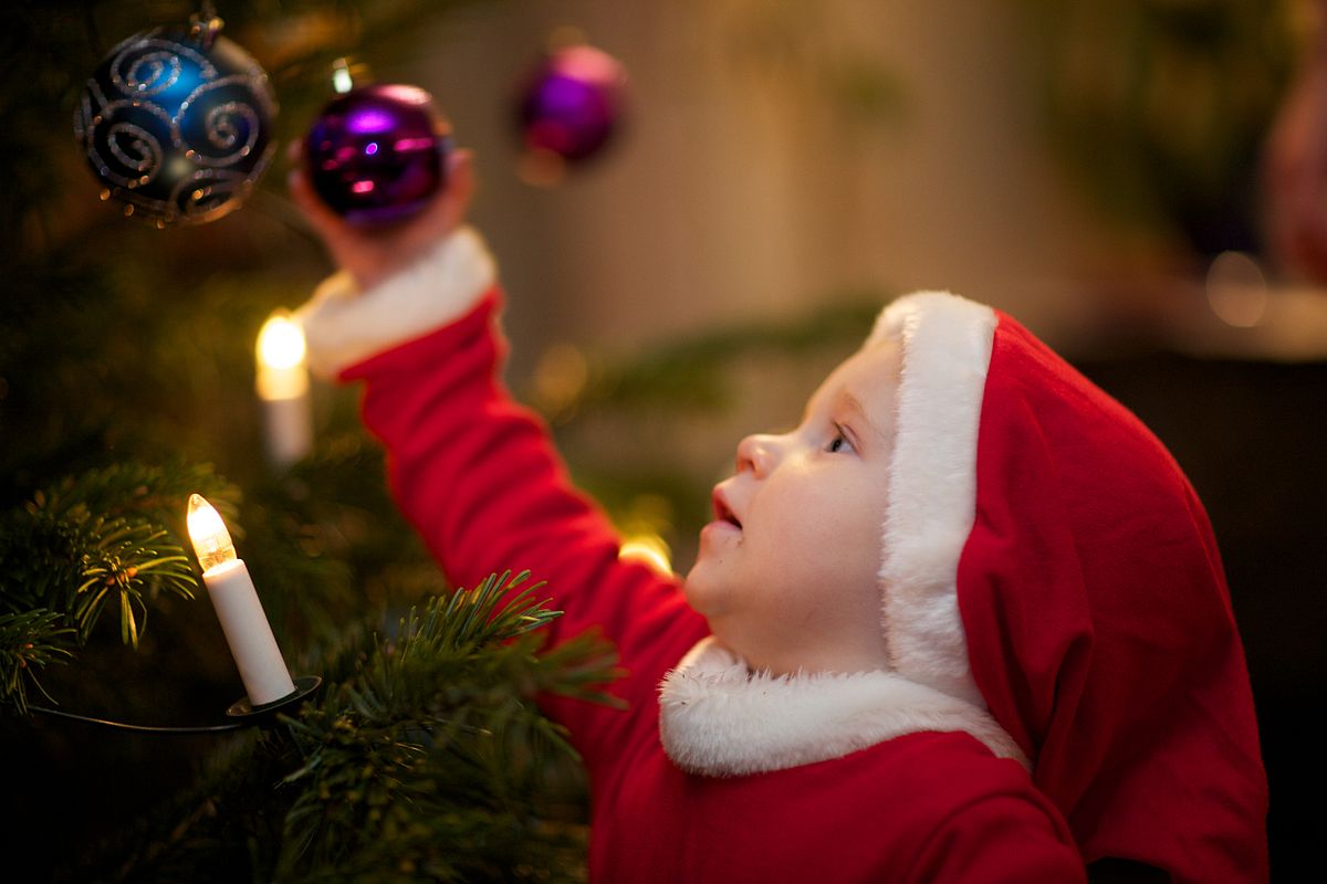 child decorating christmas tree 