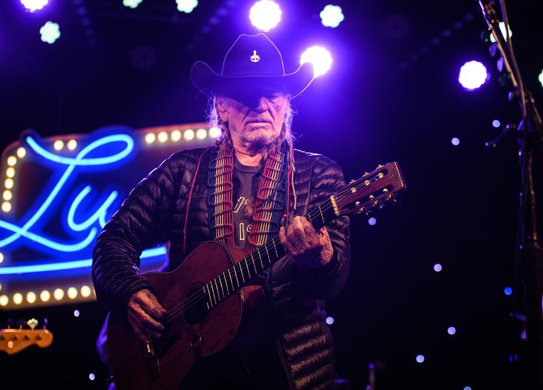 willie nelson performing guitar 