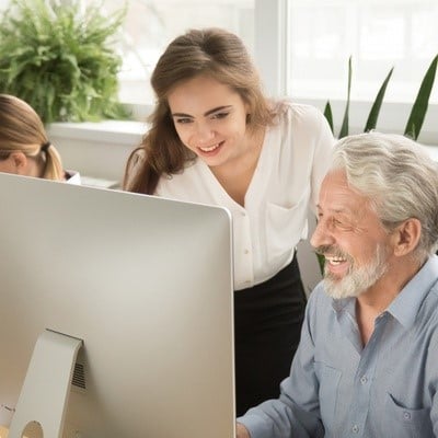 young and older worker at a computer