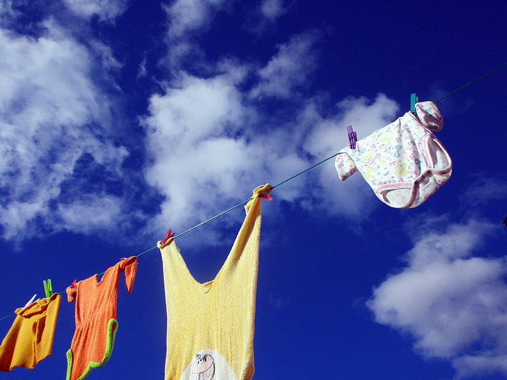 four assorted-color clothes hanging on rope