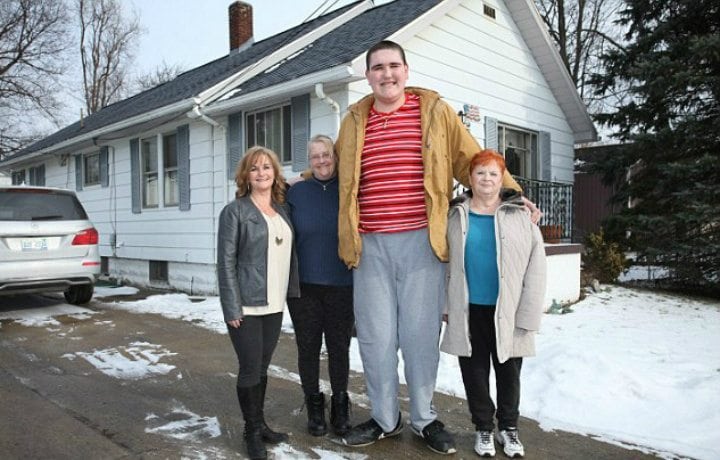 Broc standing alongside his family