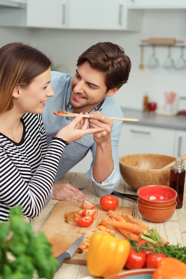 tasting food with a wooden spoon