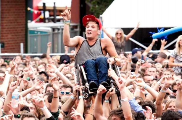 man in wheelchair gets lifted up at concert