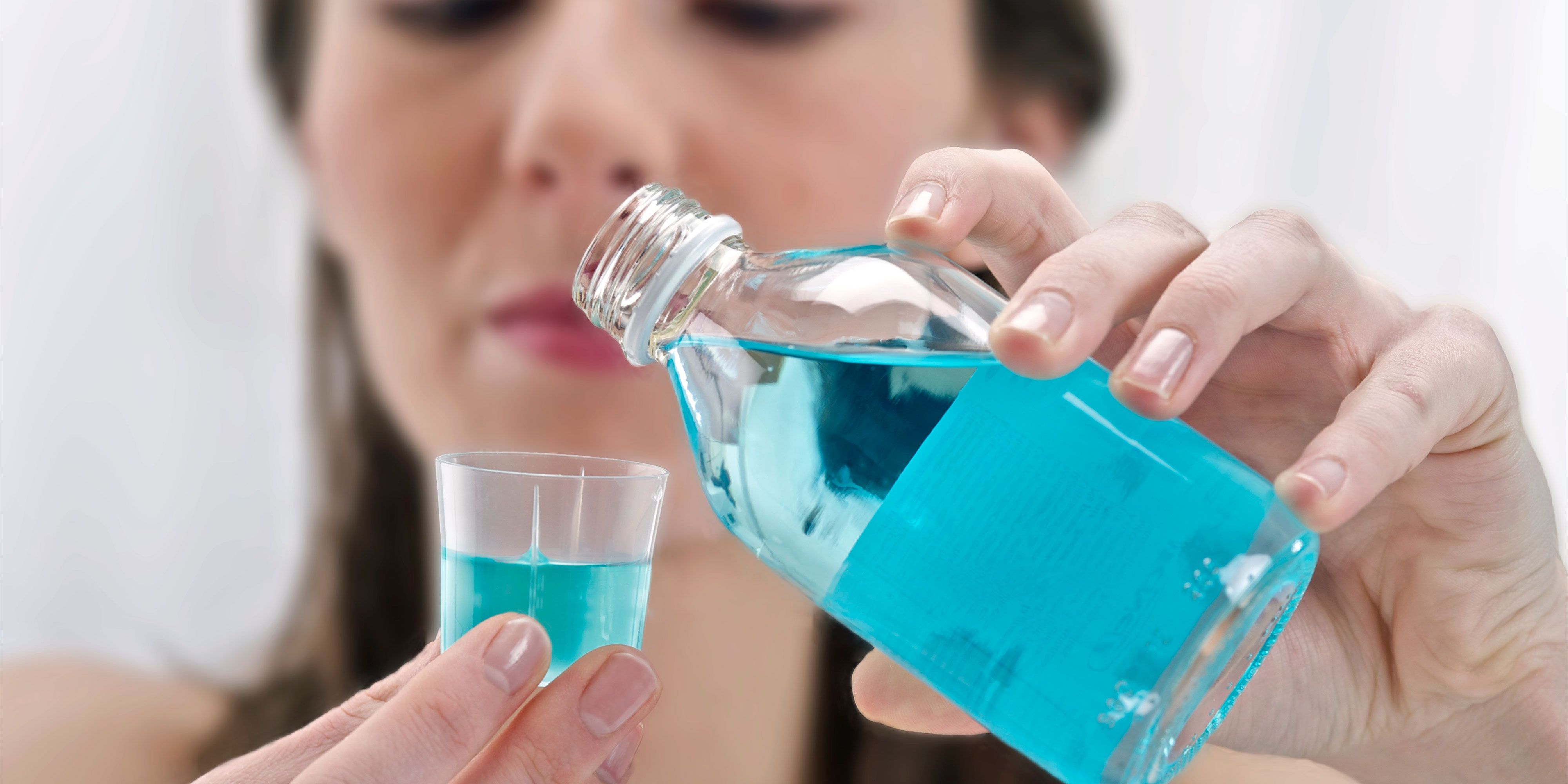 woman taking mouthwash