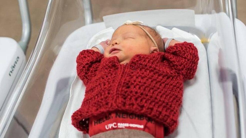 newborns dress up in red cardigans 