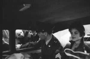 In this picture, Elvis Presley sits in uniform beside his girlfriend Priscilla