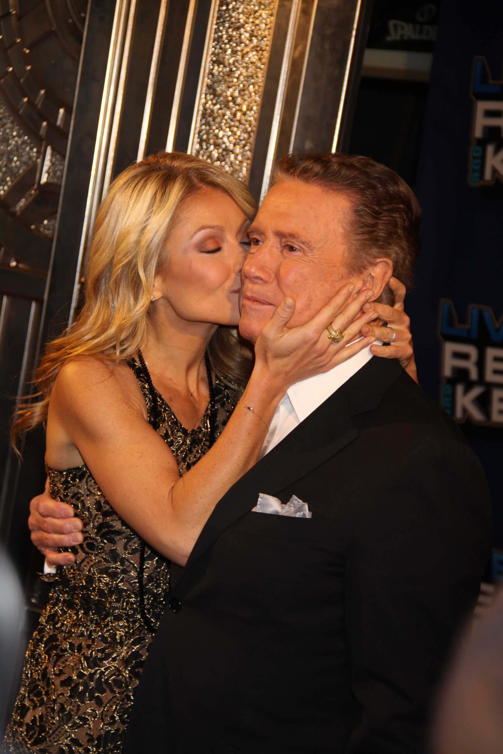 kelly ripa kissing regis philbin on the cheek at his farewell show