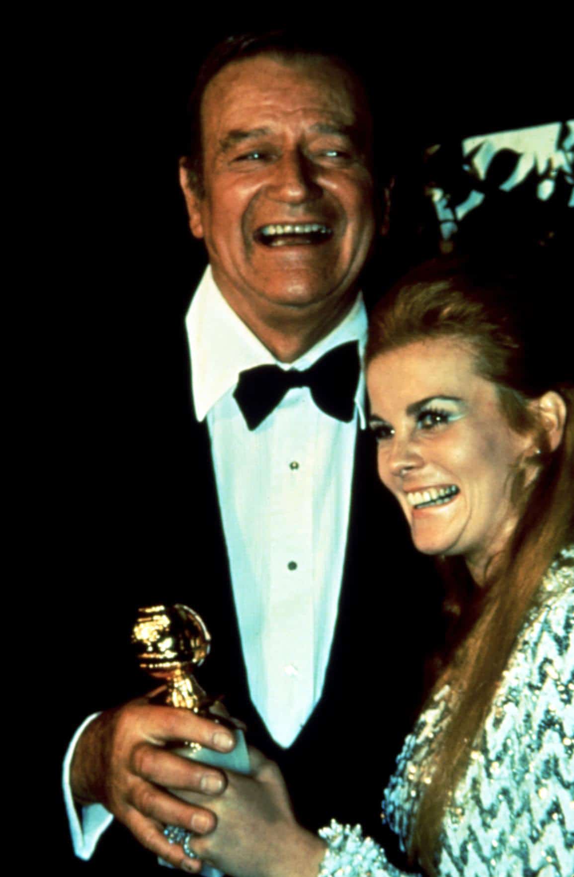 John Wayne and Ann-Margret accept Golden Globe Award