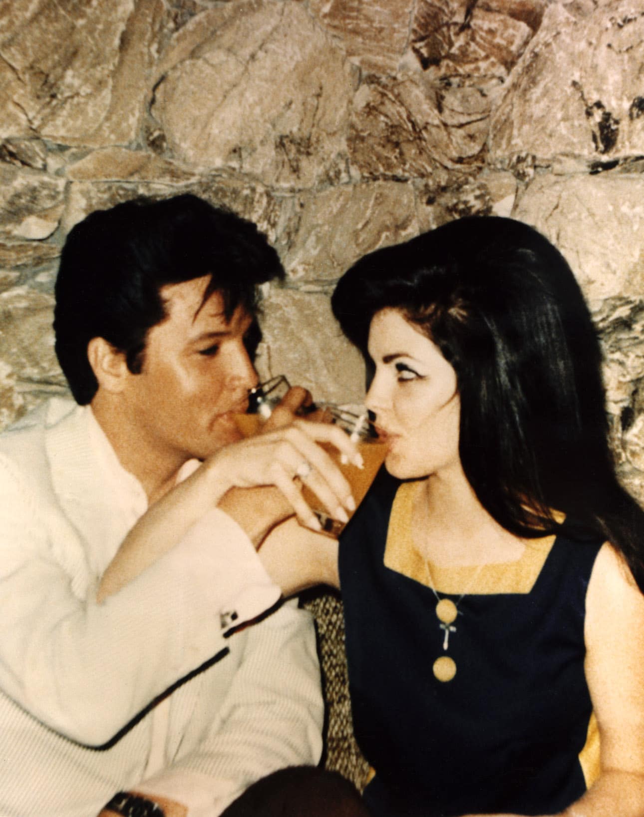 Newlyweds ELVIS PRESLEY and PRISCILLA PRESLEY toast each other after the ceremony, 1967