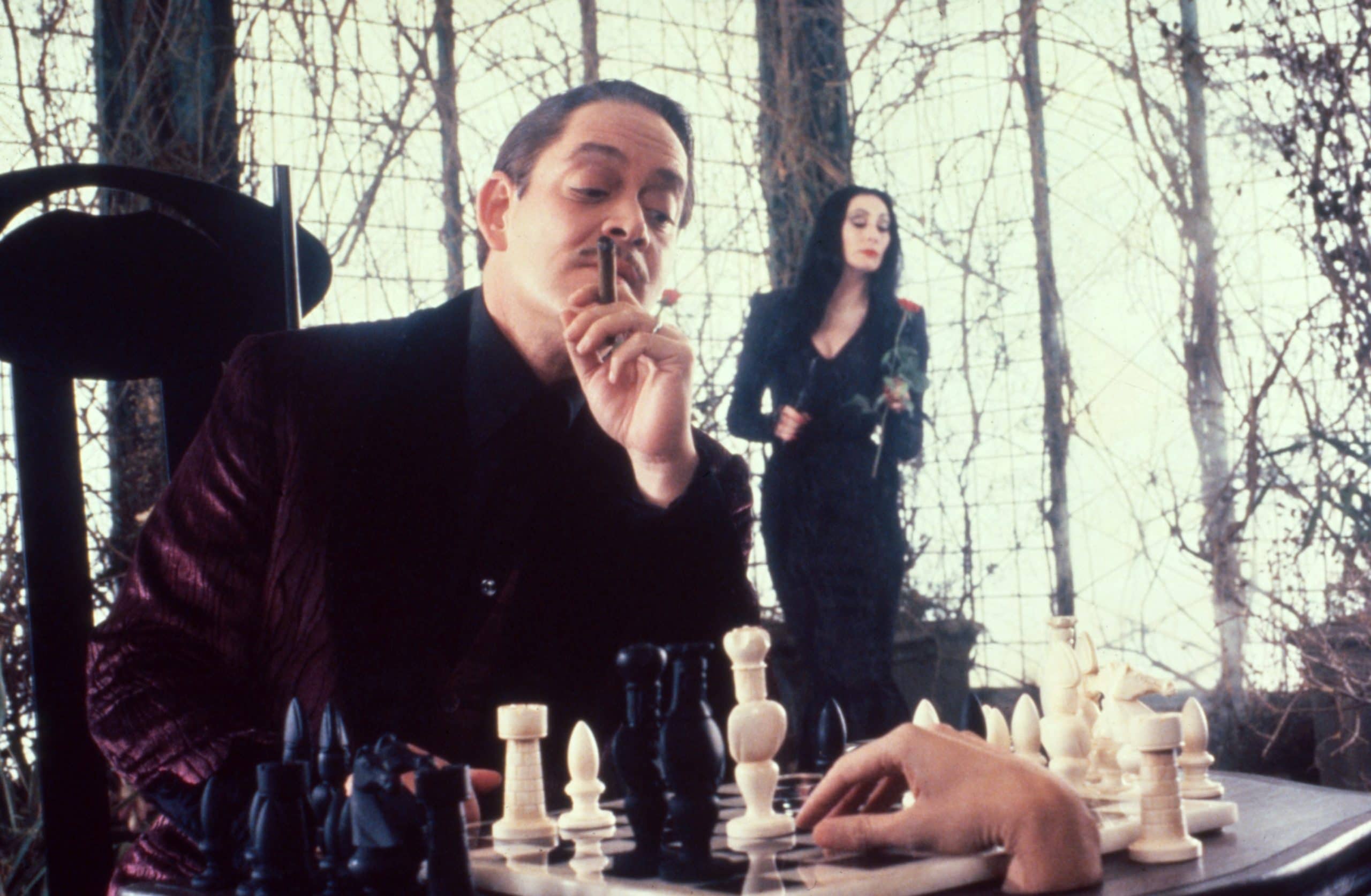 THE ADDAMS FAMILY, from left: Raul Julia, Thing; background: Anjelica Huston, 1991