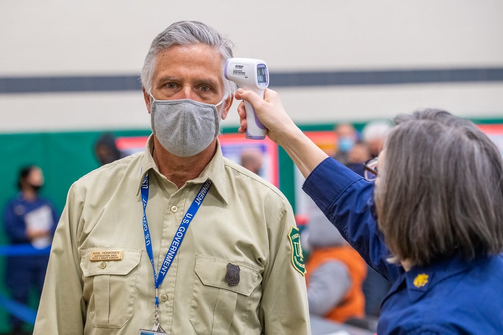 Man wearing facemask and getting temperature taken