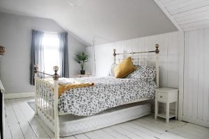 A typical bedroom features light, neutral colors and sturdy hardwood floors