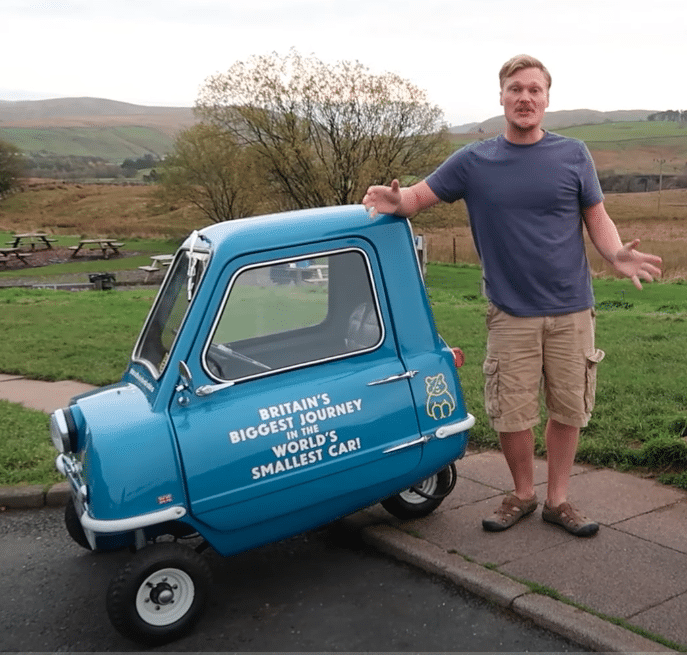 Alex Orchin poses next to his world's smallest car 