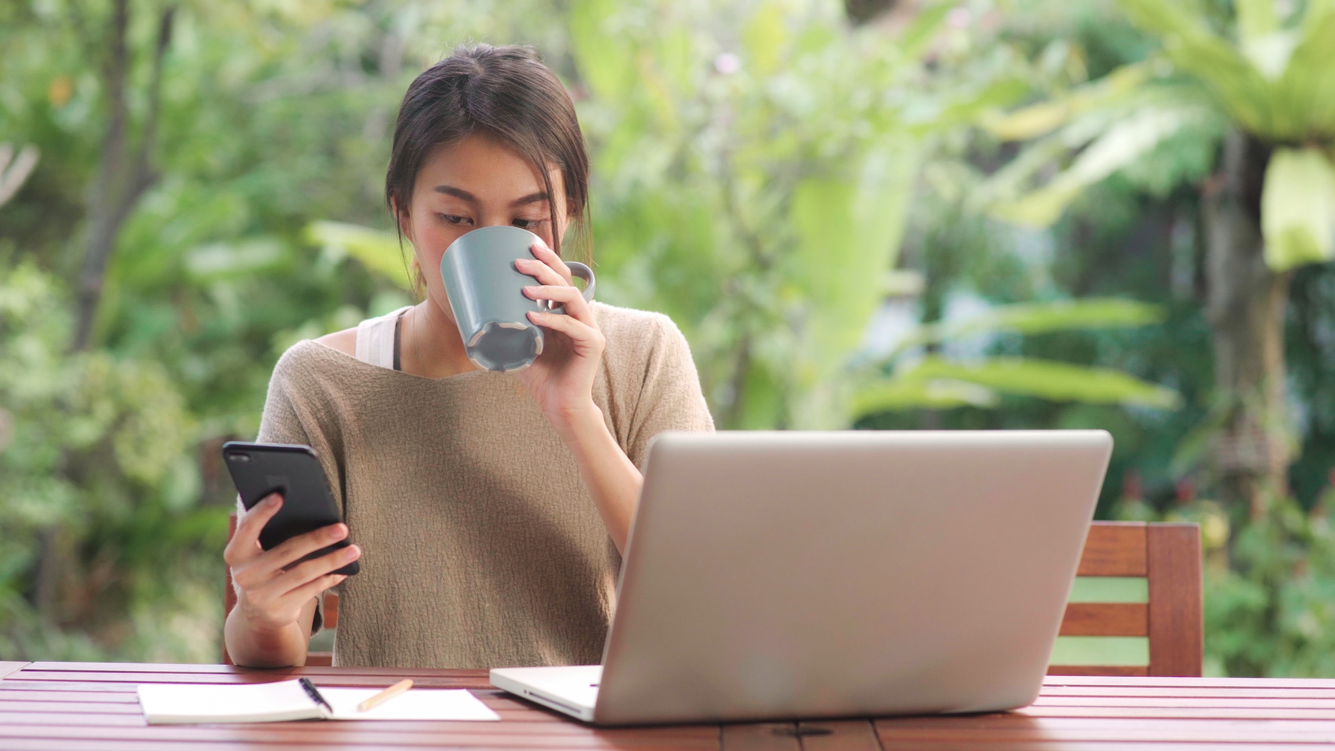 Woman using her phone and laptop 