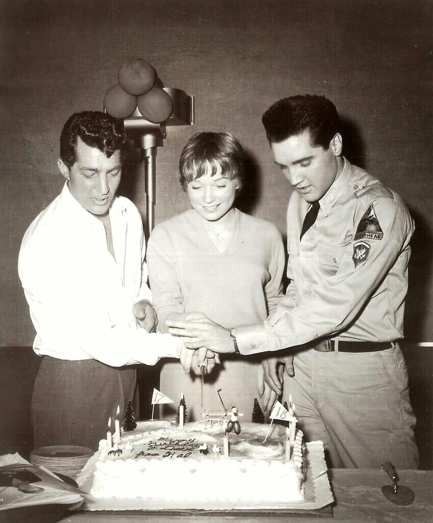 ALL IN A NIGHT'S WORK, from left: Dean Martin celebrates his birthday with help from Shirley MacLaine and visitor Elvis Presley, on set, 1961