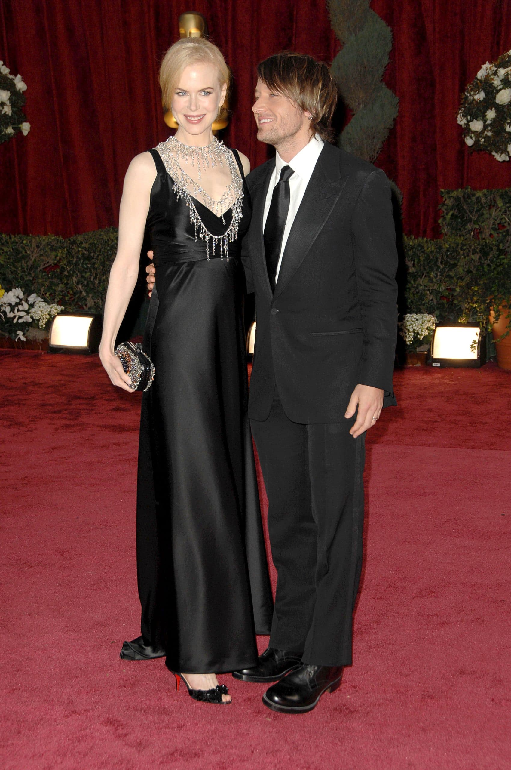 Nicole Kidman (wearing a Balenciaga dress, L'Wren Scott necklace, and carrying a Bottega Veneta clutch), Keith Urban