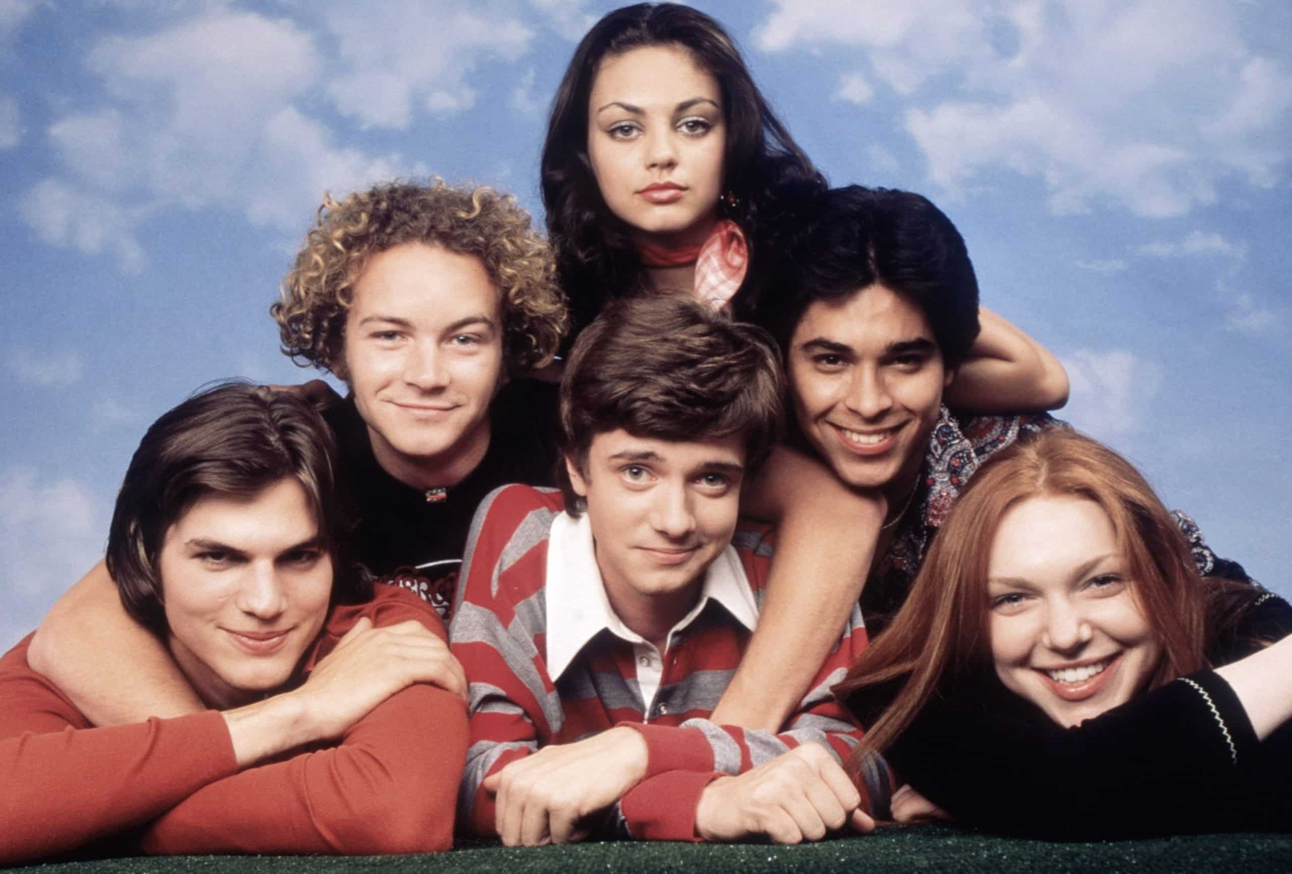 THAT '70S SHOW, cast photo. Clockwise from bottom center: Topher Grace, Ashton Kutcher, Danny Masterson, Mila Kunis, Wiler Valderrama, Laura Prepon, (Season 2), 1998-2006