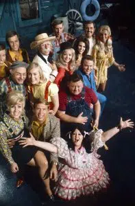 HEE HAW, top, from left: Jim Hager, Jon Hager (the Hager Twins), Gordie Tapp (hat), Stringbean (David Akeman, top, center), Archie Campbell (mustache), Gunilla Hutton, middle row, from left: Grandpa Jones (Louis Marshall Jones), Cathy Baker, Jeannine Riley (black hat), Junior Samples (stripes), Lisa Todd, Roy Clark (blue suit), front, from left: Mary Taylor, Buck Owens, Lulu Roman
