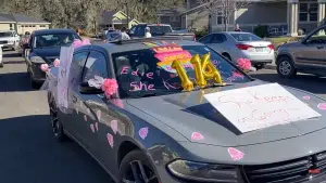 Decorated cars drive by to celebrate her historic life