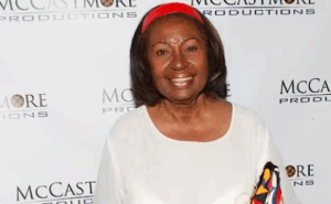 Lynn Hamilton wearing a white top and red headband at a McCastmore Productions red carpet event
